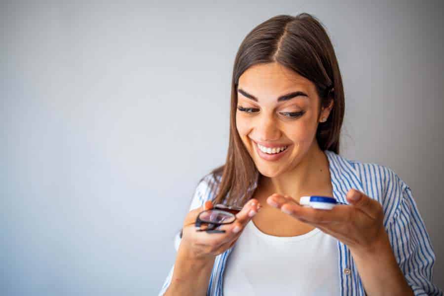 Women choosing between eyeglasses and contact lenses. stock photo